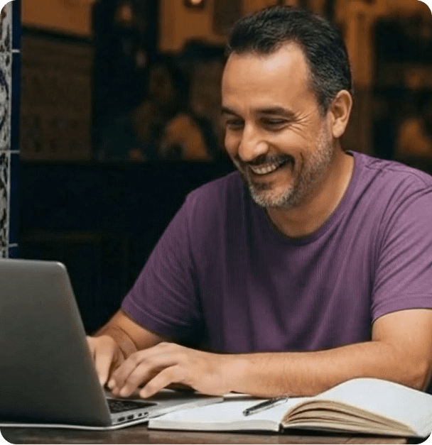 Empreendedor sorrindo enquanto trabalha no notebook